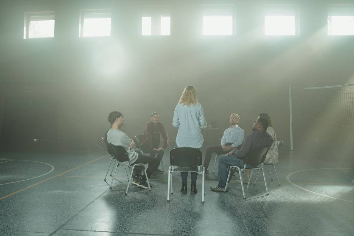 La facilitadora, de espaldas, ante el círculo del grupo durante un taller